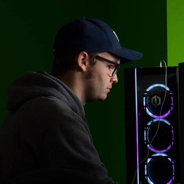 A male student using on of the computers in the arcade